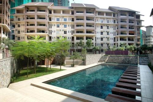 a swimming pool in front of a large building at Acuk Stay - Seri Maya Condo Homestay in Kuala Lumpur