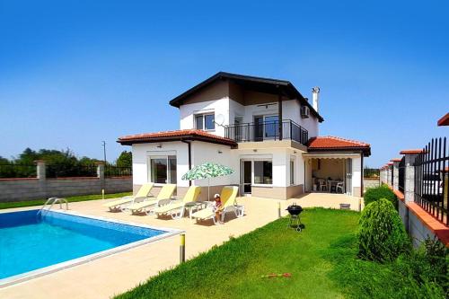 uma villa com uma piscina e uma casa em Golf Villa Ariel em Kavarna