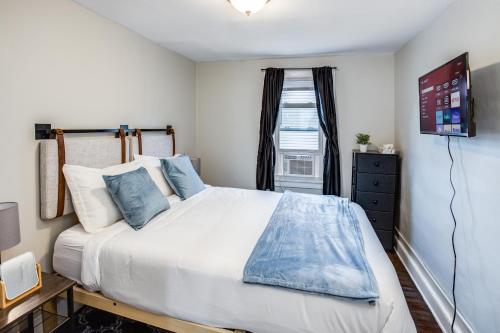 ein Schlafzimmer mit einem großen weißen Bett mit blauen Kissen in der Unterkunft 3BR Home with In-Unit Laundry, Parking, Sound Bar in Rochester