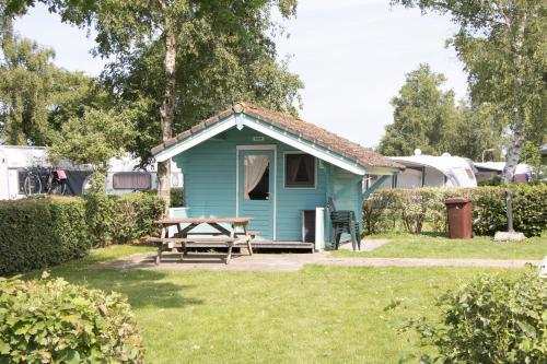 a blue shed with a picnic table in a yard at Camping Kleine Belterwijde, Trekkershut in Belt-Schutsloot