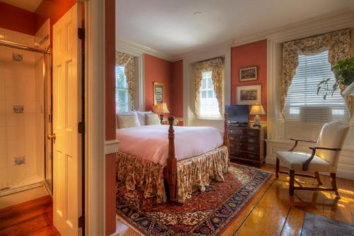 a bedroom with red walls and a bed and a chair at Francis Malbone House in Newport