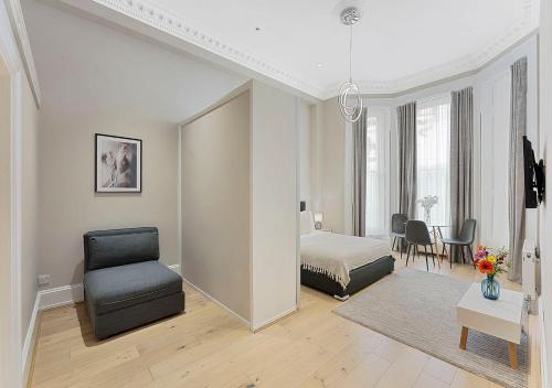 een slaapkamer met een bed en een stoel in een kamer bij Cleveland Residences Kensington in Londen