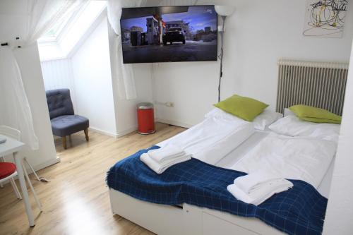 a bedroom with a bed and a tv on the wall at Pension Waldhof am Stubenbergsee in Stubenberg
