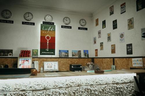 una habitación con relojes en la pared y un mostrador en LOFT HOSTAL Group, en Lloret de Mar