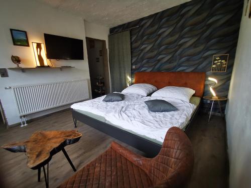 a bedroom with a bed and a table and a chair at Landhaus Messerschmitt in Böchingen