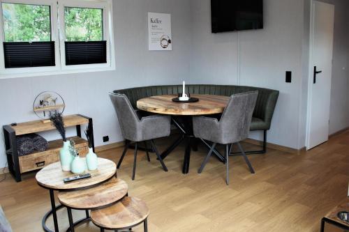 een kamer met een tafel en stoelen en een televisie bij Ferienhaus Aurora, Sauna, Seeblick, angeln in Twist