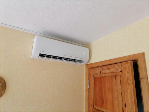 a ceiling air conditioner in a room with a door at Brīvdienu māja Pūces in Līgatne