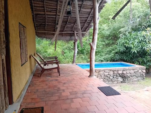 a patio with a bench and a swimming pool at Wild Wadi Wilpattu - Villas with private Plunge Pools in Wilpattu