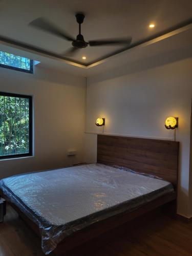 a bedroom with a bed with a ceiling fan at Dream Lodging in Silchar
