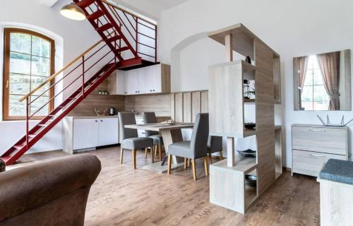 a living room with a staircase and a table and chairs at Apartmány Lucia Baňa in Vyšný Medzev