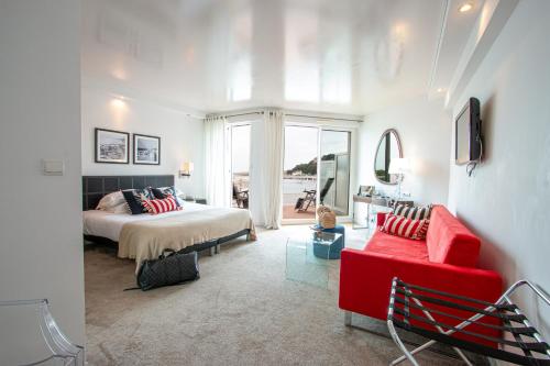 a bedroom with a bed and a red couch at Hôtel La Marine in Barneville-Carteret