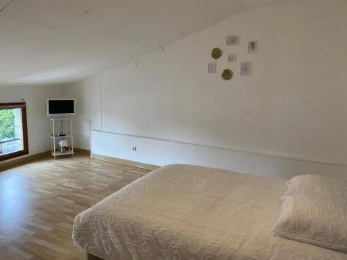 a white bedroom with a bed and a television at Maison Triplex à deux pas du centre ville in Saint-Dizier