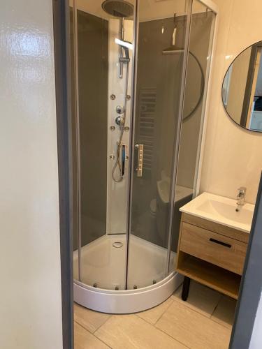 a shower with a glass door in a bathroom at Maison Triplex à deux pas du centre ville in Saint-Dizier