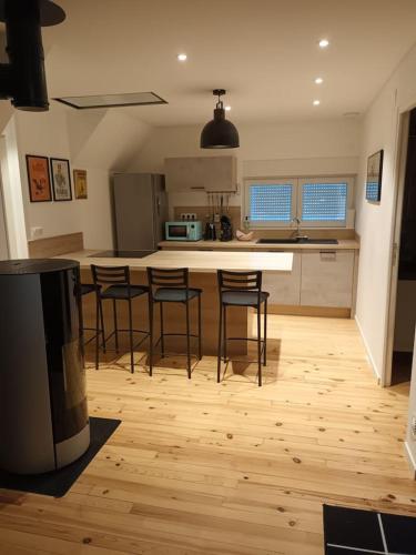 - une cuisine avec tabourets de bar et comptoir dans l'établissement Gite a l' Orée du verger, à Griesbach-au-Val