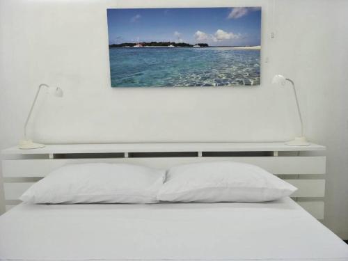 a white bed with two lights on top of it at KASPOZ Entire Holiday Home - Private garden & 5 mins walk to the beach in Mont Choisy
