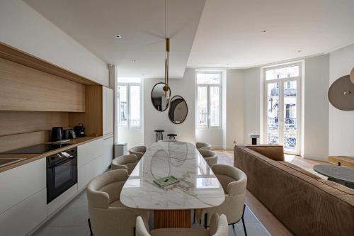 une cuisine et une salle à manger avec une table et des chaises dans l'établissement Superbe appartement 120m2 au coeur de Cannes, à Cannes