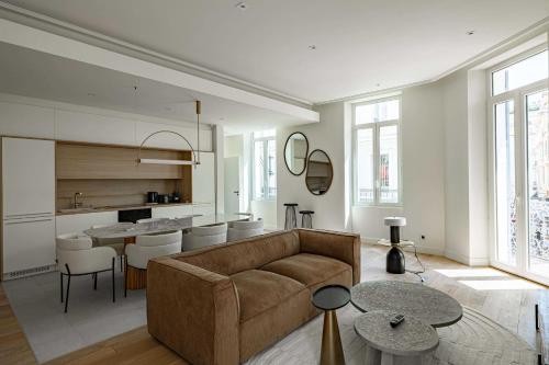 un salon avec un canapé et une cuisine dans l'établissement Superbe appartement 120m2 au coeur de Cannes, à Cannes