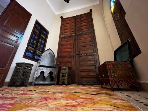 Pokój z dużymi drewnianymi drzwiami i oknem w obiekcie Riad Dar Zaouia w Marakeszu