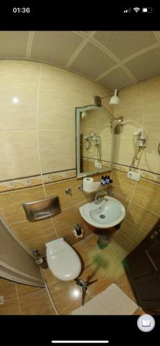 a bathroom with a sink and a toilet and a mirror at Monastery cave Hotel Cappadocia in Mustafapaşa