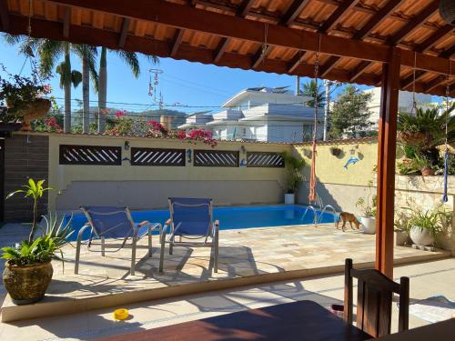um pátio com cadeiras e uma piscina em casa 300 mts da praia em Juqueí