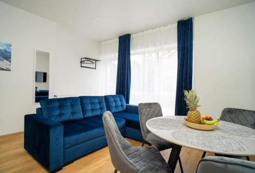 een woonkamer met een blauwe bank en een tafel bij Fort63 house in Kaunas