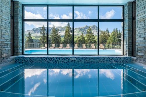 a swimming pool with a view of the mountains through windows at Résidence Pierre & Vacances Premium Les Terrasses d'Eos in Flaine