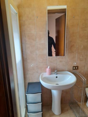 a bathroom with a white sink and a mirror at Central Apartment Torino N.22 in Olbia