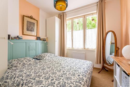 a bedroom with a blue bed and a mirror at Les Potiers RdC - proche centre historique in Arras