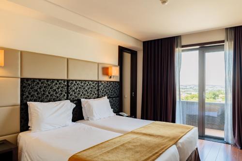 Ένα ή περισσότερα κρεβάτια σε δωμάτιο στο Axis Porto Business & Spa Hotel