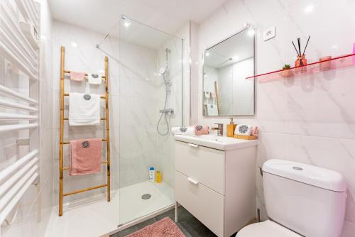 a white bathroom with a shower and a toilet at Les Potiers RdC - proche centre historique in Arras