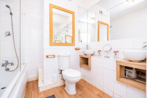 a white bathroom with a toilet and a sink at Classic Marble Arch Apartment in London