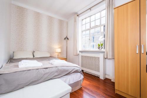 una camera con un grande letto e una finestra di Classic Marble Arch Apartment a Londra