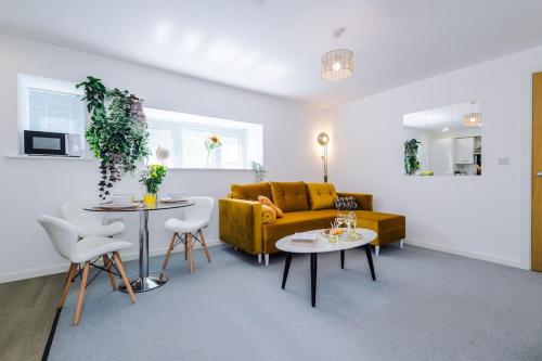 a living room with a yellow couch and two tables at Yellow Bridge - 2 Bed Luxury Apartment in Amley