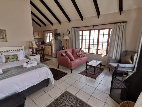 a bedroom with a bed and a couch and chairs at Eagles' Rock in Underberg