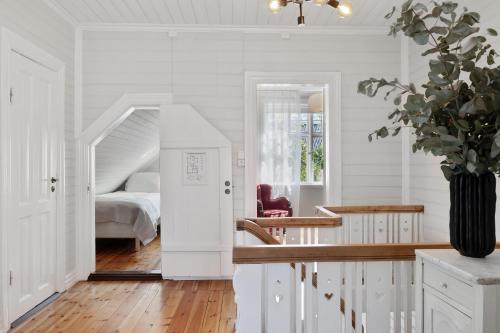 a white bedroom with a bed and a vase of flowers at Luxury Villa in Downtown Reykjavik in Reykjavík