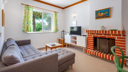 a living room with a couch and a fireplace at Casa Mia by LovelyStay in Lagoa