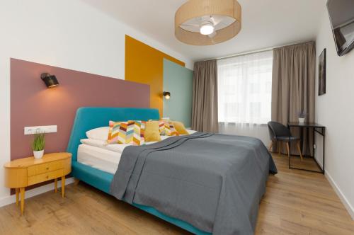 a bedroom with a blue bed with colorful walls at Stylish Apartment Warsaw Downtown by Renters in Warsaw