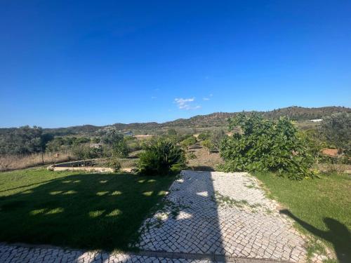 a walkway in a field of grass with a blue sky at Quinta with orange and lemon trees in Silves