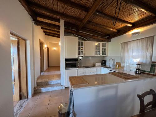 a kitchen with white cabinets and a large island at Quinta with orange and lemon trees in Silves
