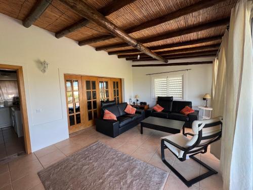 a living room with a couch and a chair at Quinta with orange and lemon trees in Silves