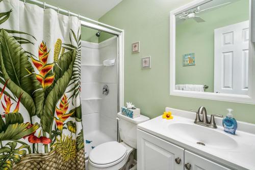 a bathroom with a sink and a toilet and a shower curtain at Kona Isle B5 in Kailua-Kona
