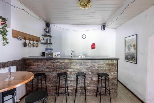 a bar in a restaurant with stools at Hartkaiser Rooms and Apartments in Ellmau