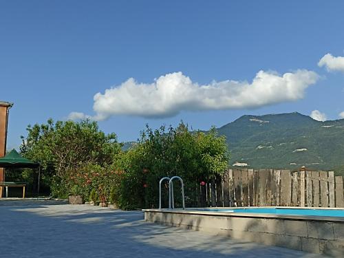a swimming pool with a fence and mountains in the background at Green Garden in Ijevan