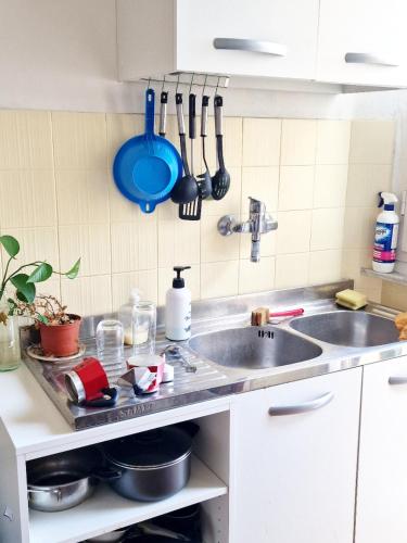 a kitchen counter with a sink and utensils on the wall at Monstera room Vicino al centro in Perugia
