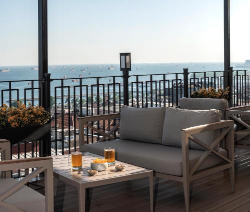 a couch on a balcony with a view of the ocean at Aprilis Hotel - Special Category in Istanbul