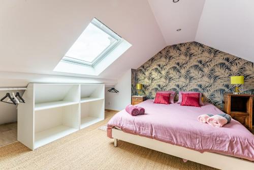 um quarto com uma cama com lençóis cor-de-rosa e uma janela em Les Potiers 2 - charmant appartement en duplex em Arras