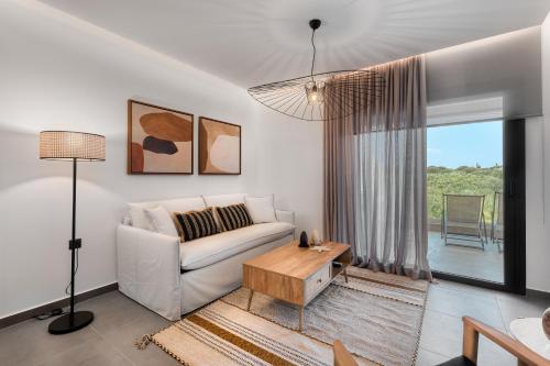 a living room with a white couch and a table at Sezian Boutique Homes and Villas in Preveza