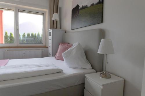 a bedroom with a white bed and a window at Ferienwohnungen BergArt in Iselsberg