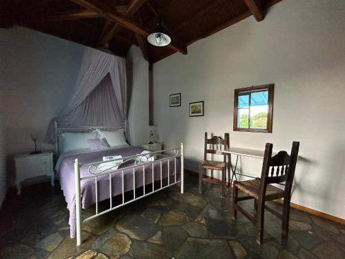 1 dormitorio con 1 cama, mesa y sillas en ORPHEAS TRADITIONAL HOUSE, en Centro histórico de Alónnisos