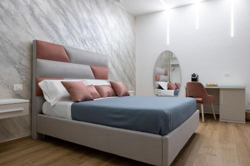 a bedroom with a bed and a desk and a mirror at Sunbay Luxury Rooms in Vieste